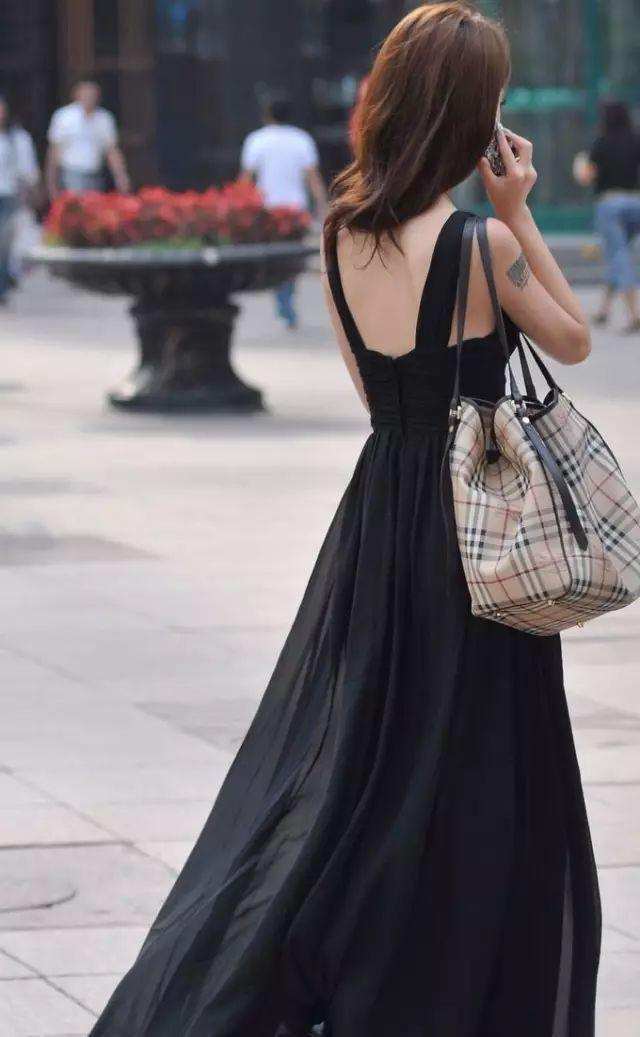街拍:穿黑色吊带连衣裙的美女,她的纹身很能吸