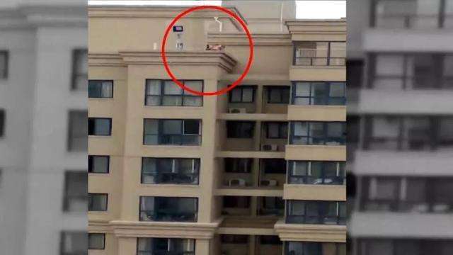 居民阳台晾衣服,看到对面楼顶有人影,放大看清