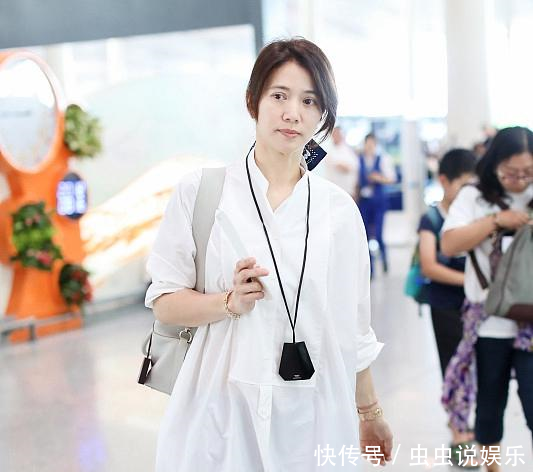 46岁袁咏仪现身机场,穿宽松白衬衫好减龄,丝巾