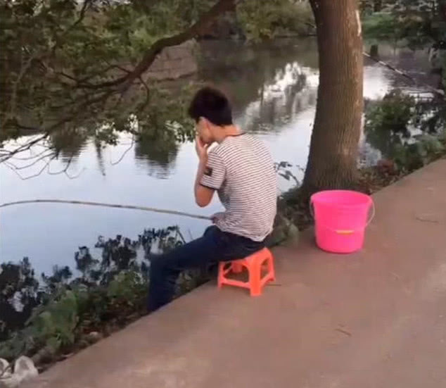 小伙坐在河岸上钓鱼,突然脖子冰凉,用手一摸吓