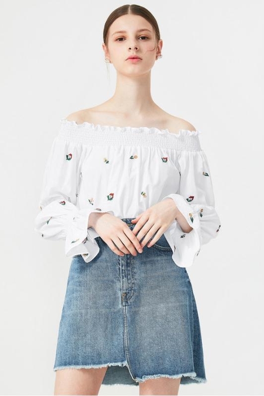 少女身穿白色一字领绣花上衣搭配牛仔半身裙,
