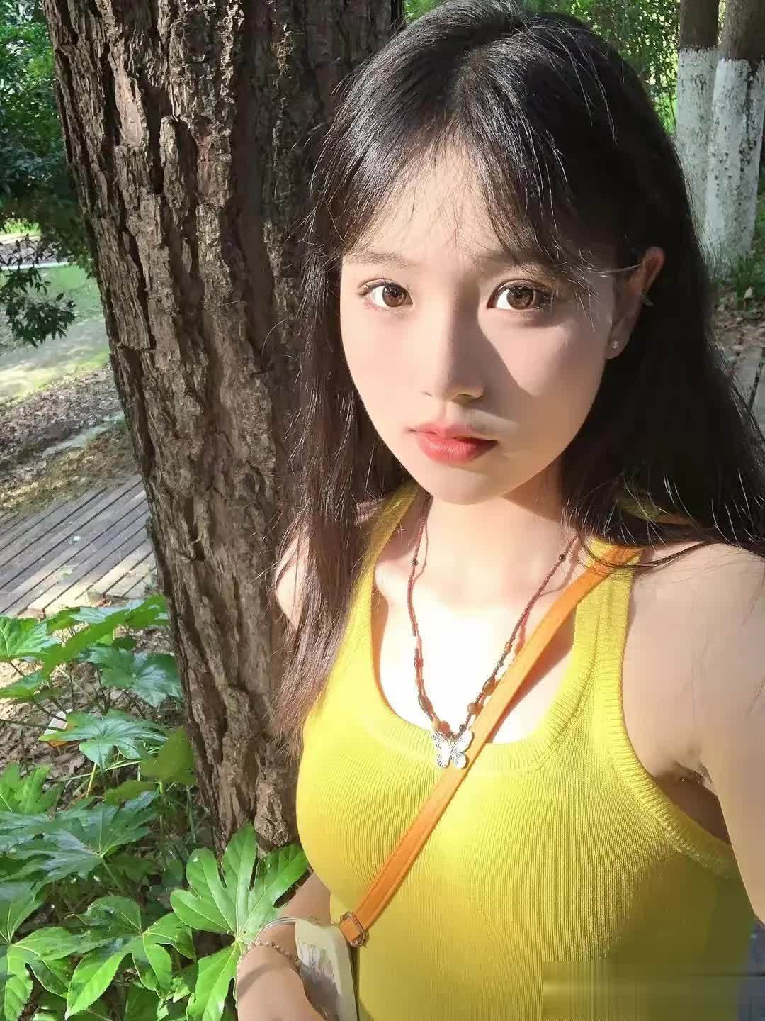 23岁黄色背心棕色头发美女,在庭院树下拍摄的写真照